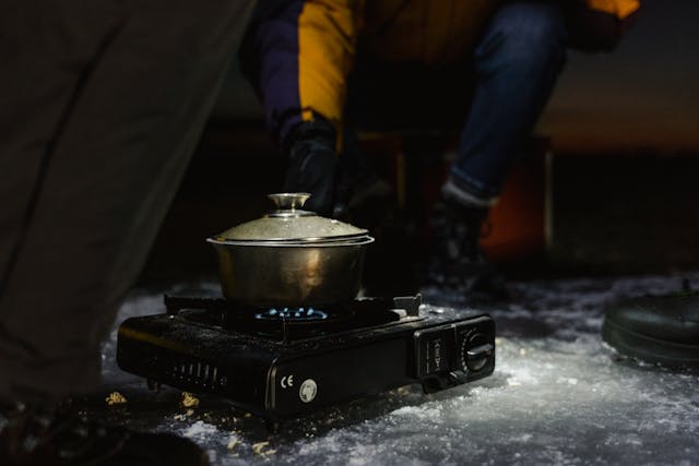 Campingkocher mit Topf in einem Zelt auf gefrorenem See